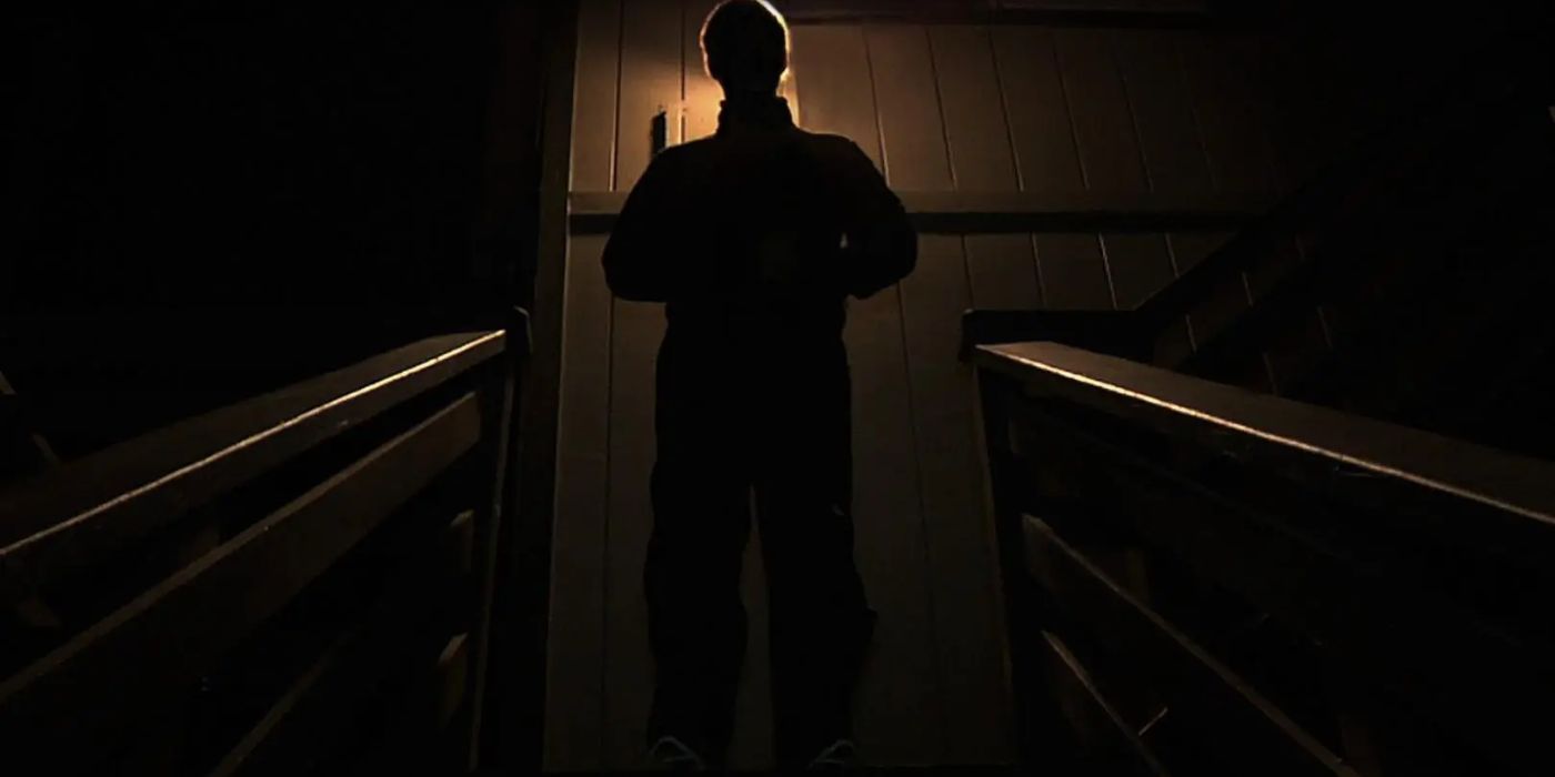 A man's silhouette standing atop a satircase in 'Creep'
