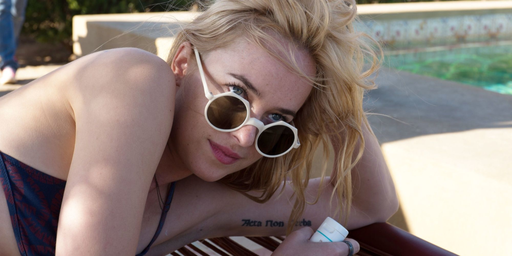 Penelope wearing sunglasses by the pool in A Bigger Splash