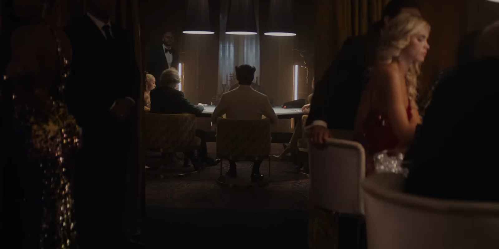 A wide-shot of people in a casino-like setting with Wolverine at the center, wearing a white suit with his back turned to the camera.