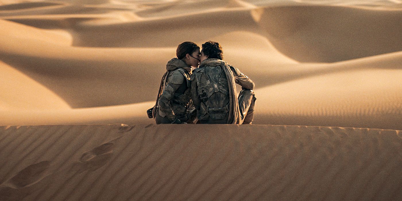 Chani (Zendaya) and Paul (Timothée Chalamet) kissing on a sand dune in Dune: Part Two