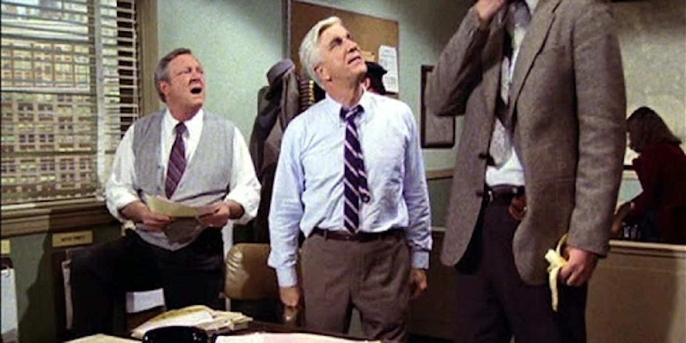 Ed Hocken (Alan North), Frank Drebin (Leslie Nielsen) looking up at Al (Ronald &ldquo;Tiny Ron&rdquo; Taylor) in &lsquo;Police Squad!'