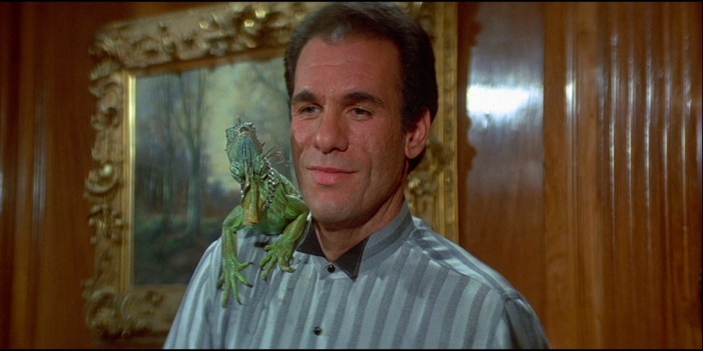 Drug kingpin Franz Sanchez (Robert Davi) stands in a room with a chameleon on his shoulder.