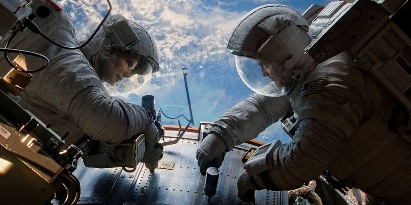 Sandra Bullock and George Clooney as Ryan and Matt chatting while fixing a machine in space in Gravity.