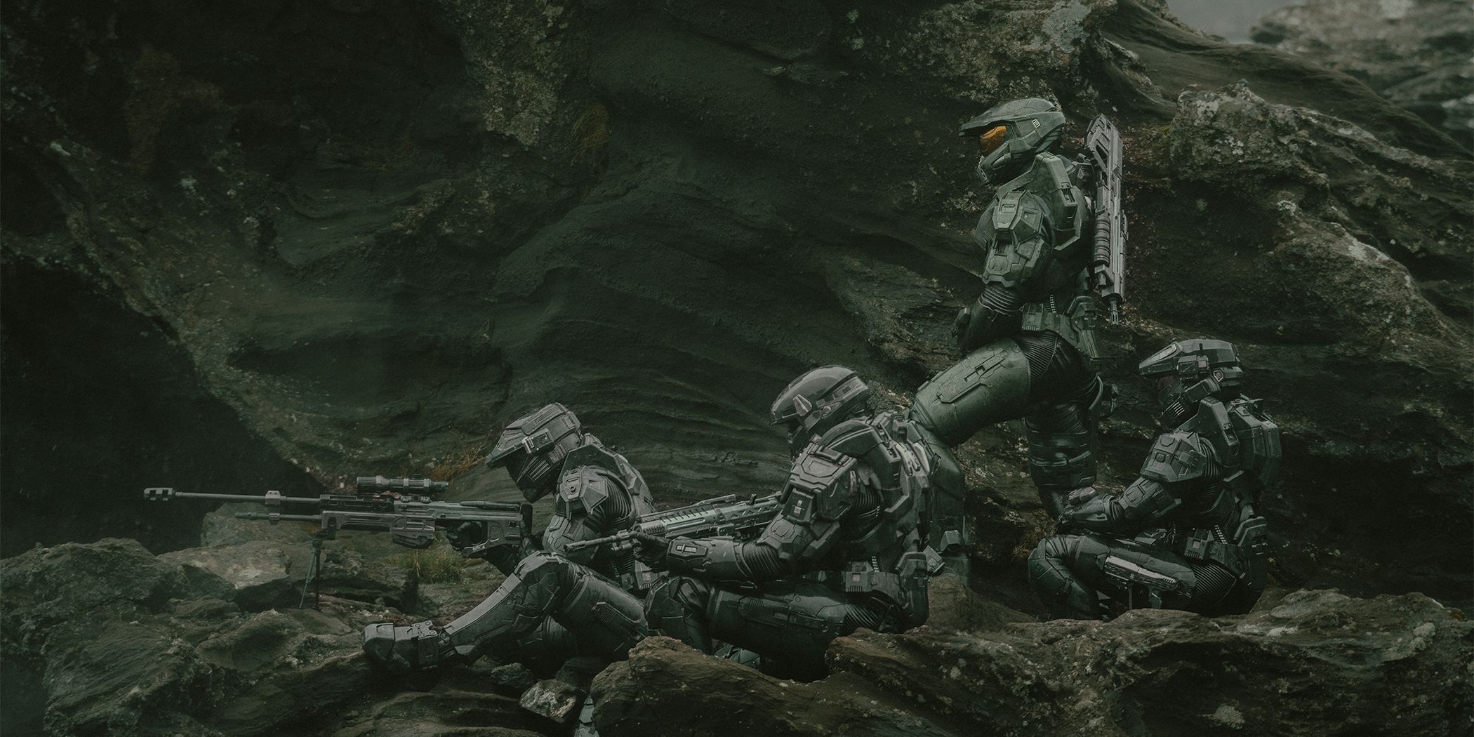 Spartans gathered on a rocky terrain, aiming weapons in Halo Season 2