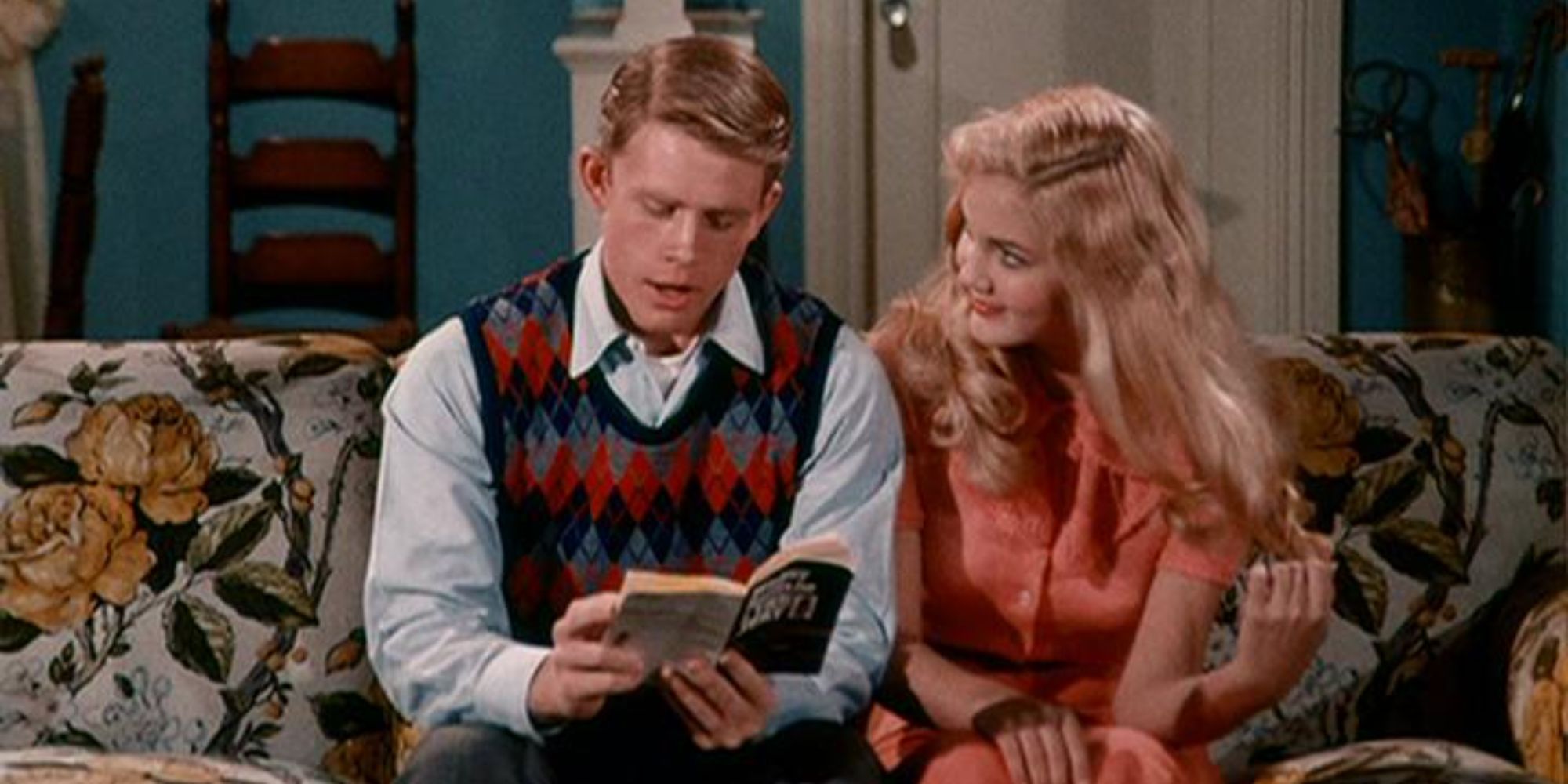 Richie Cunningham (Ron Howard) on a couch reading with Mary Lou Milligan (Kathy O'Dare) ​​​​​​​in Happy Days