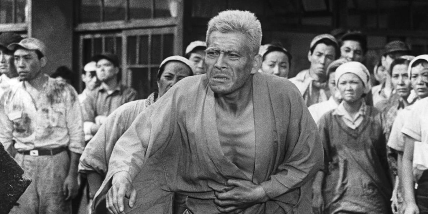 Aged Japanese man, Kiichi Nakajima (Toshiro Mifune), walks outside before a large group of people.