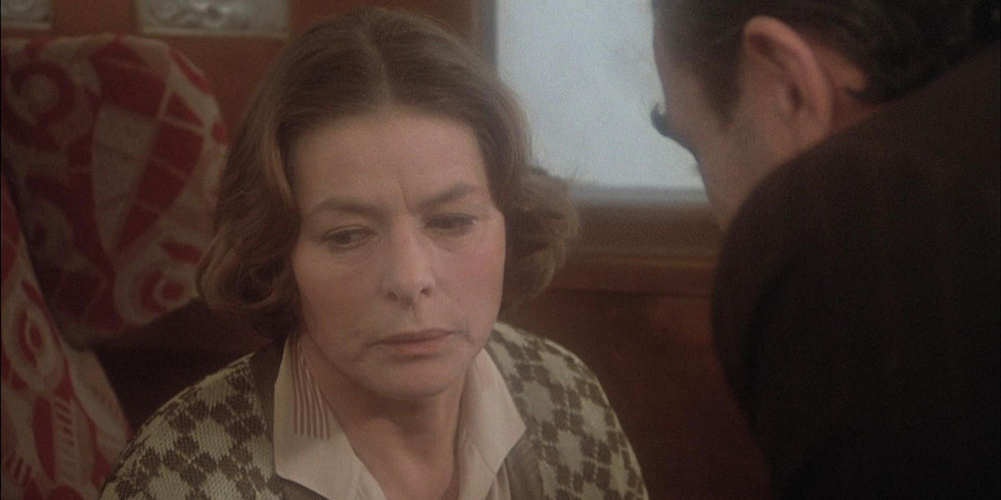 woman being interrogated on a train by a man