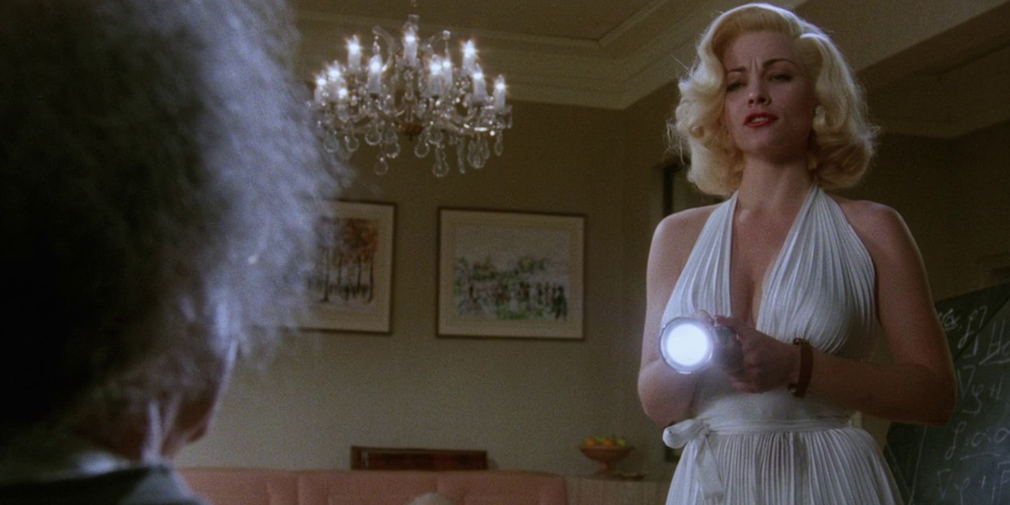 Therese Russell holding a flashlight in Insignificance.