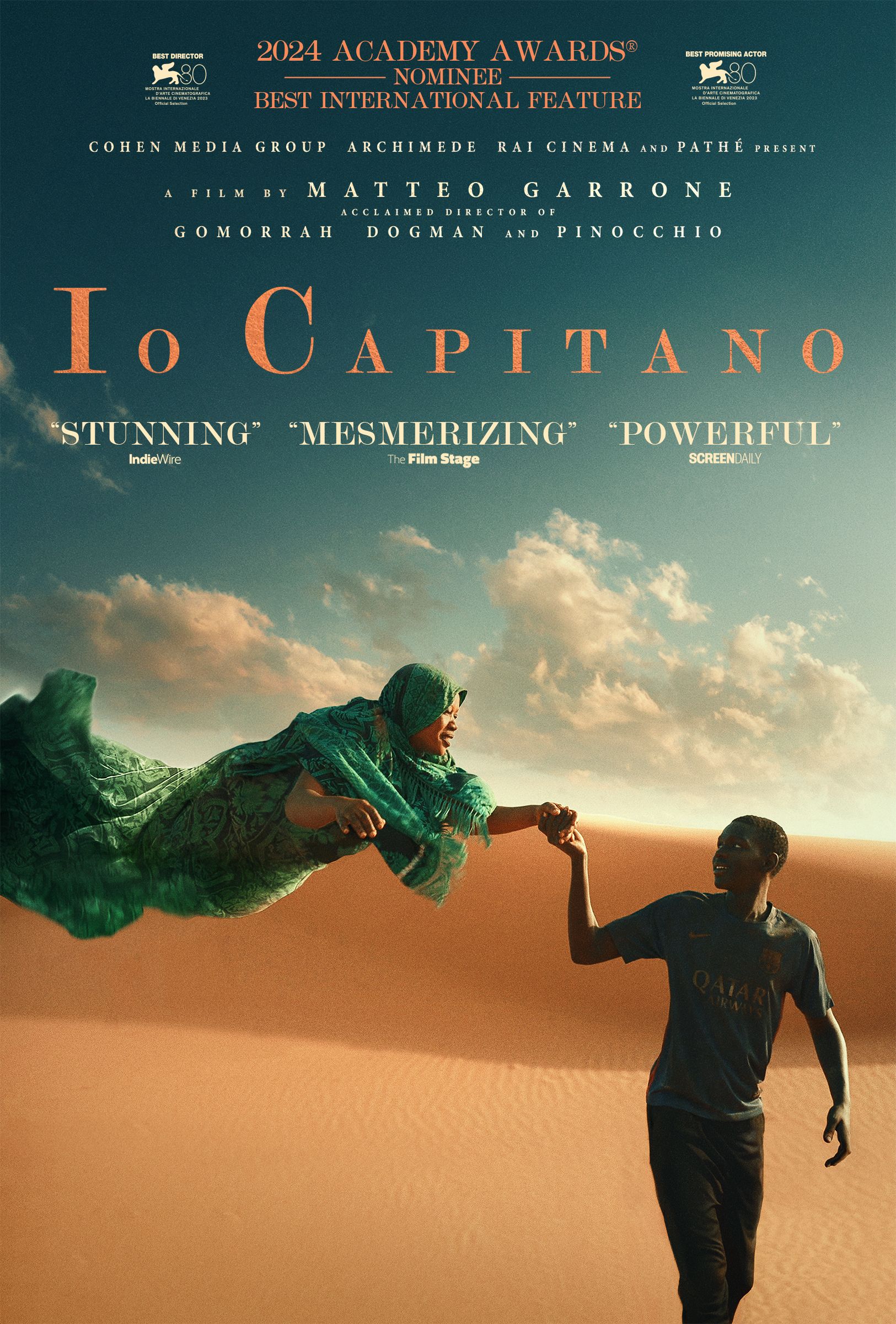 Seydou clings the hands of a floating woman in the Sahara Desert in the daytime in a poster for Io Capitano.