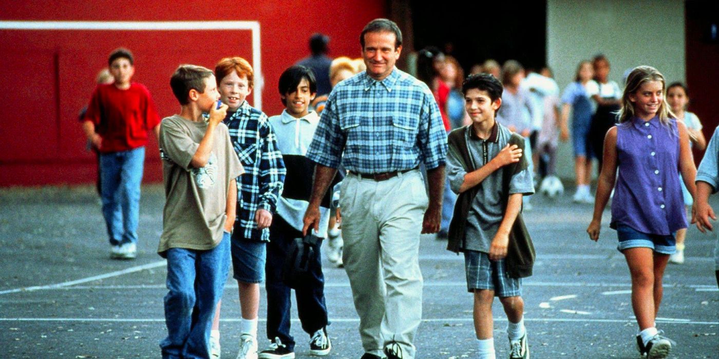 A man walks with a group of kids on the school court.