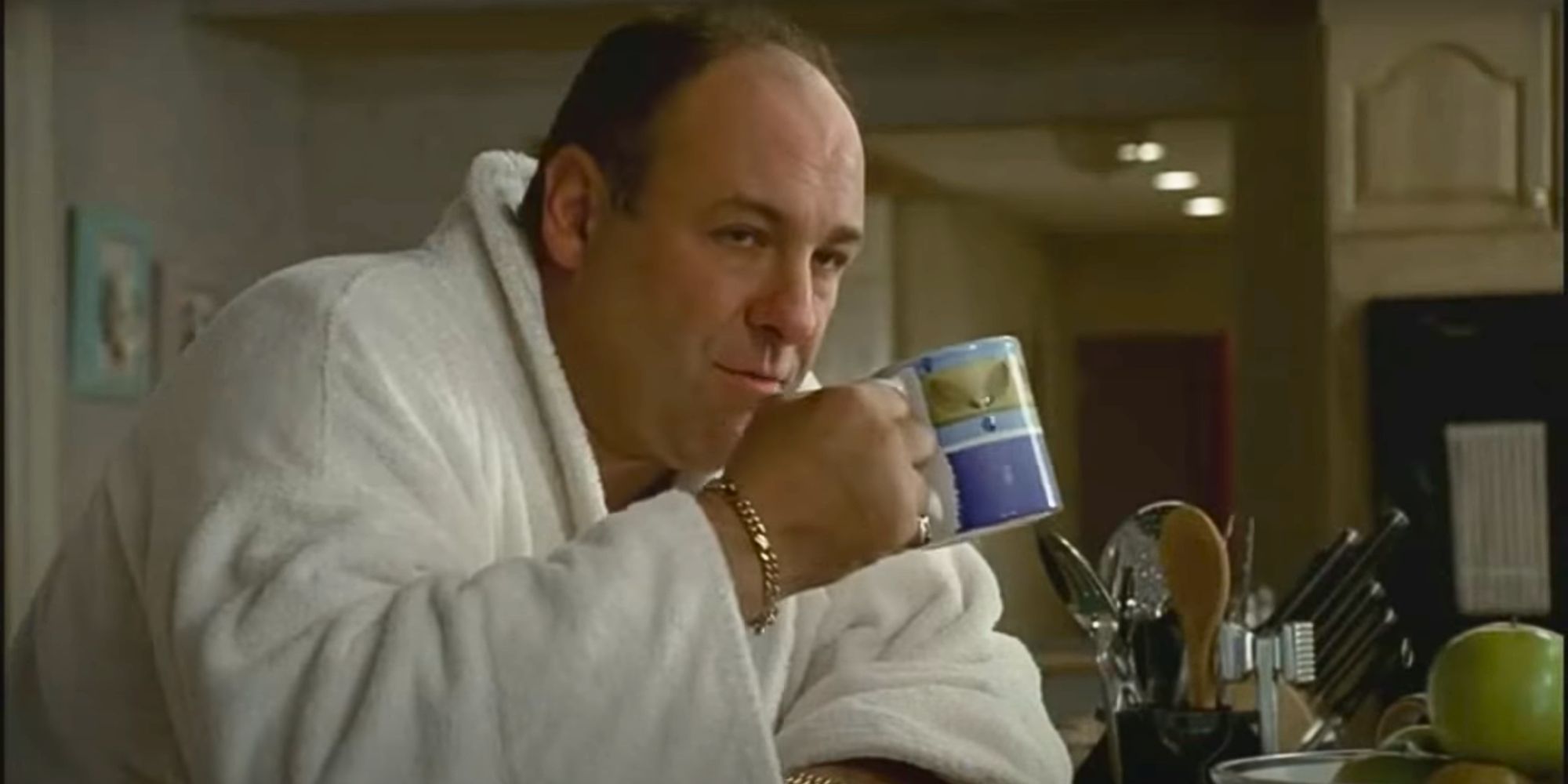 James Gandolfini sitting in a bathrobe drinking coffee in The Sopranos