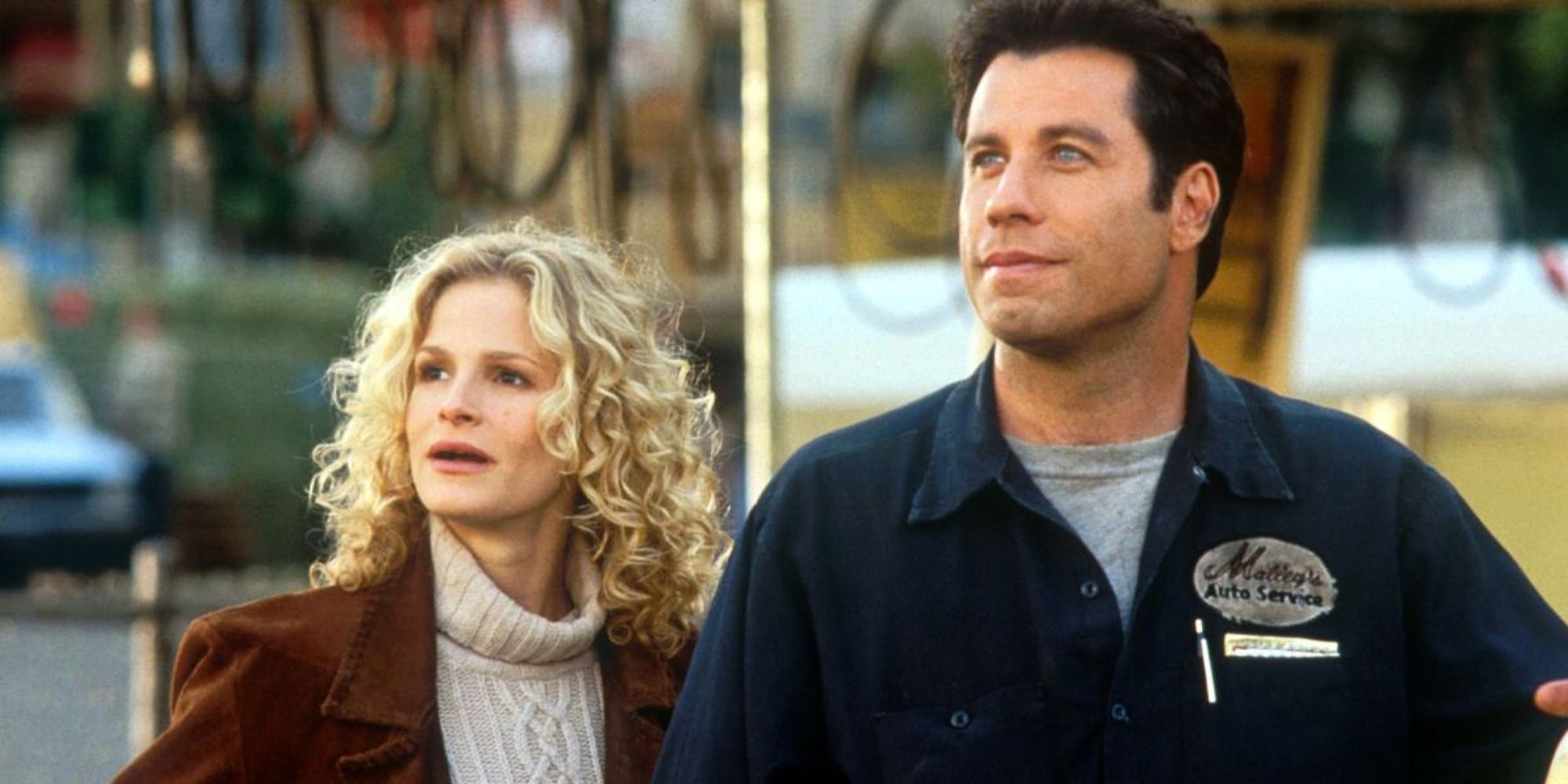 John Travolta and Kyra Sedgwick standing next to each other looking up into the sky in Phenomenon (1996)