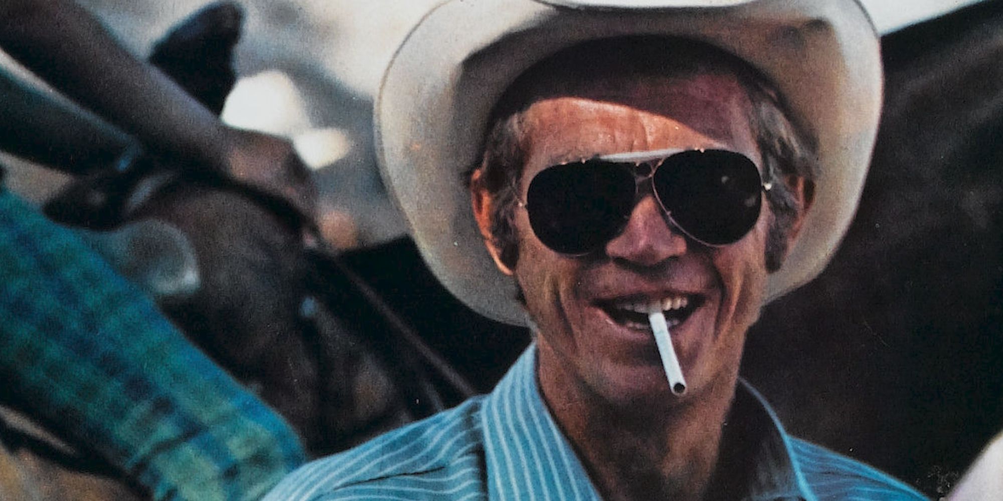 Steve McQueen as Junior Bonner smiling with a cigarette in his teeth in Junior Bonner