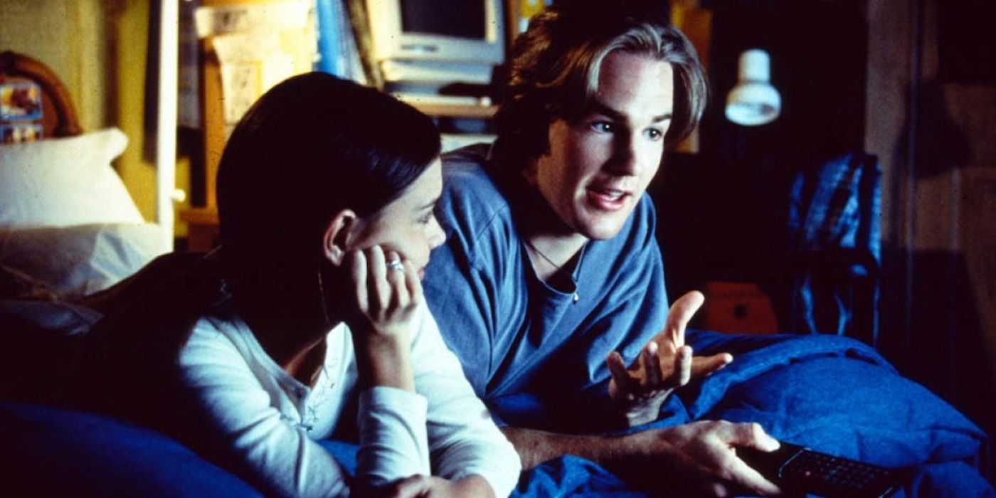 Katie Holmes and James Van Der Beek talking on a bed in Dawson&rsquo;s Creek