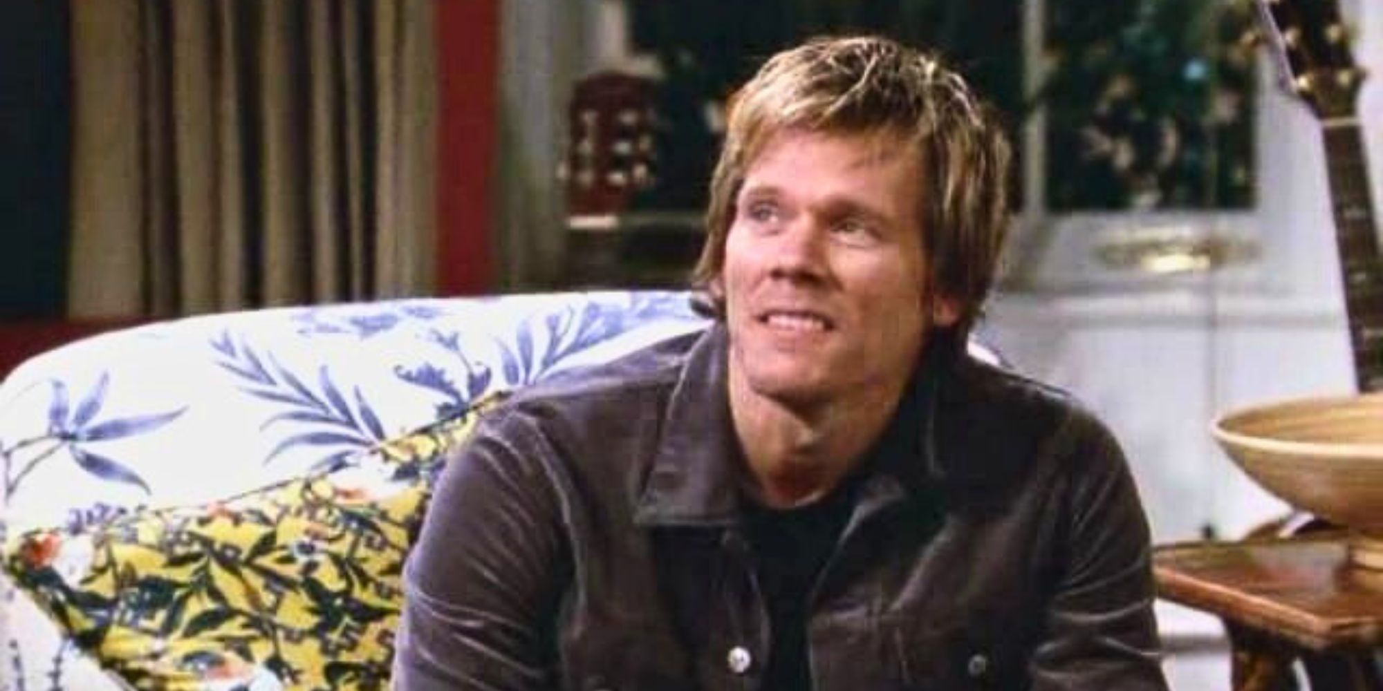 Kevin Bacon sitting on a couch in Will &amp; Grace