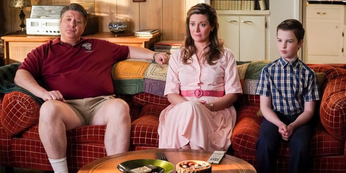 George, Mary, and Sheldon sitting on the couch looking forward in Young Sheldon