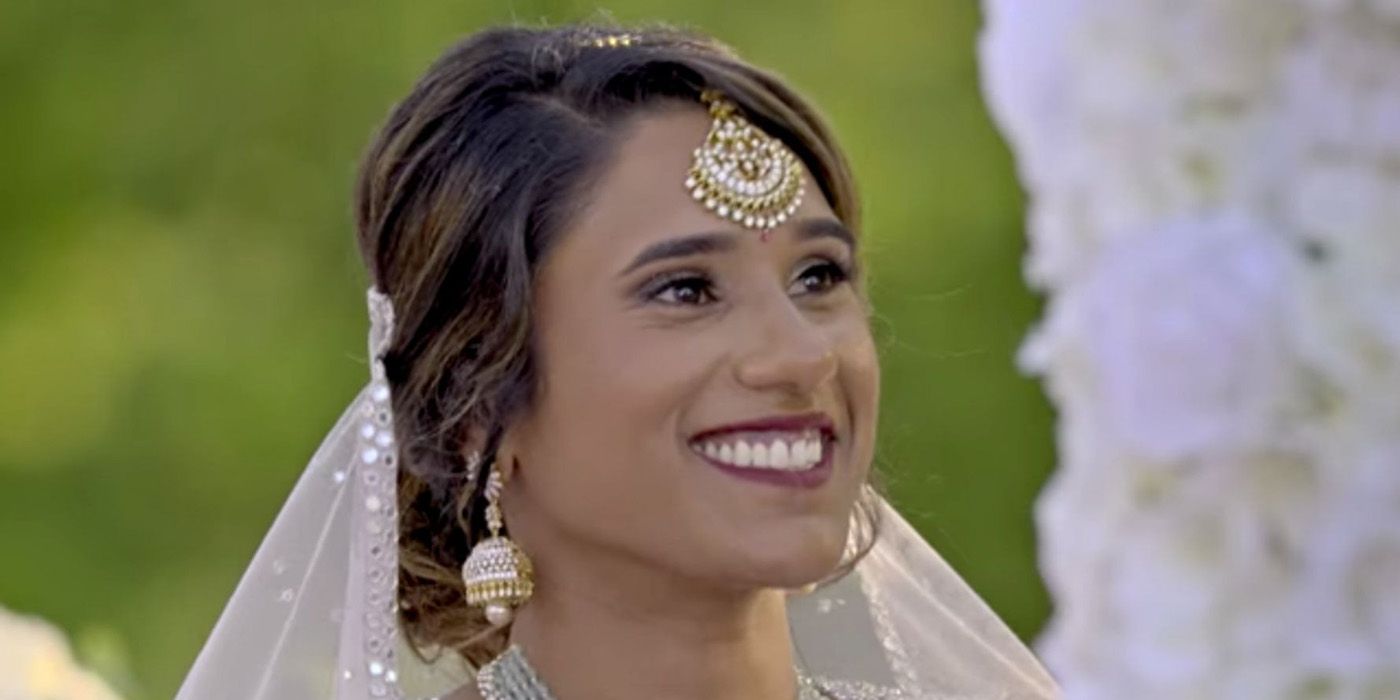 A close-up of Deepti in a bridal dress with a jewel on her forehead smiling and looking up in a scene from Love is Blind.