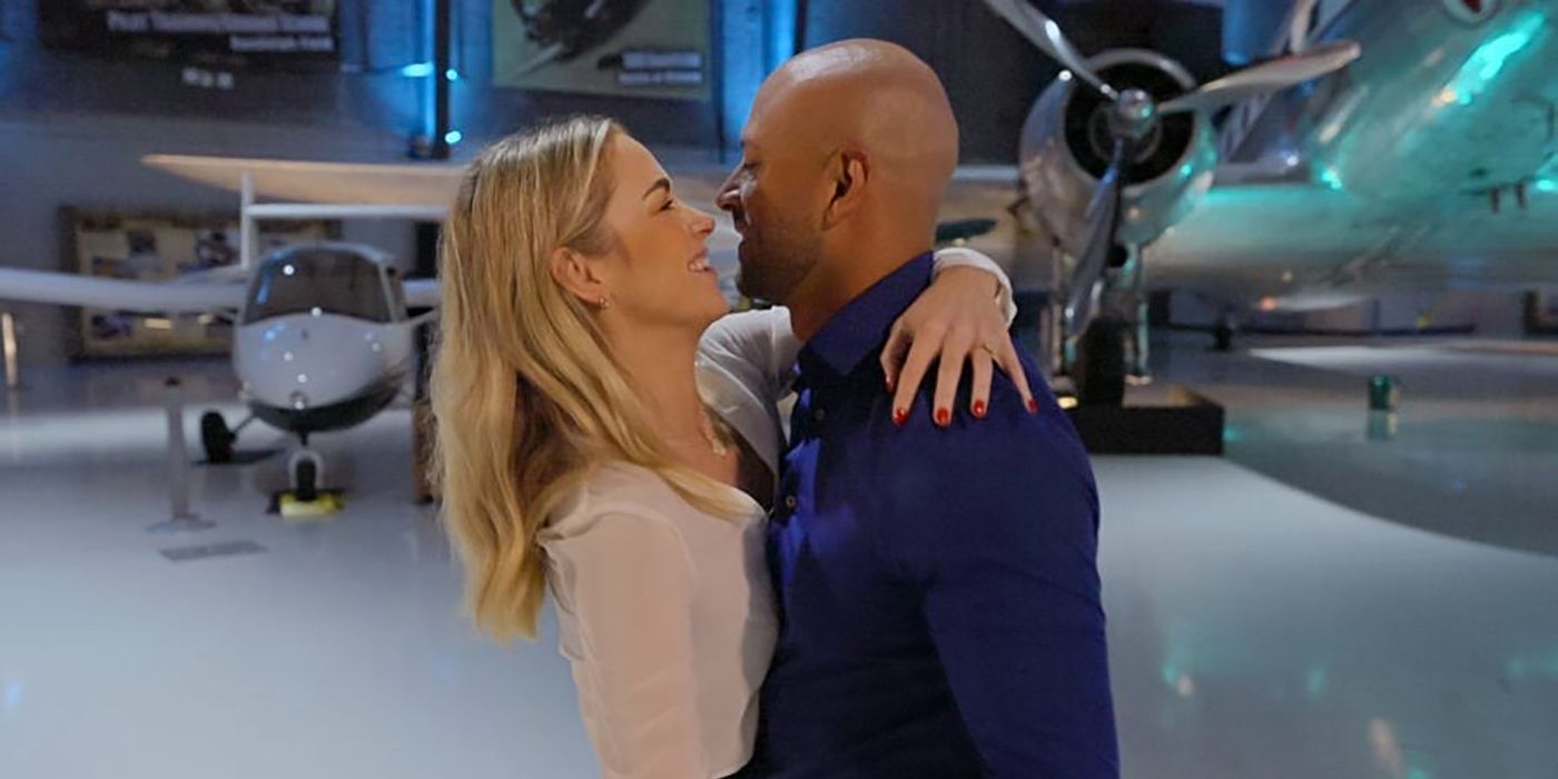Stacy and Izzy hugging one another in front of planes in a scene from Love is Blind.