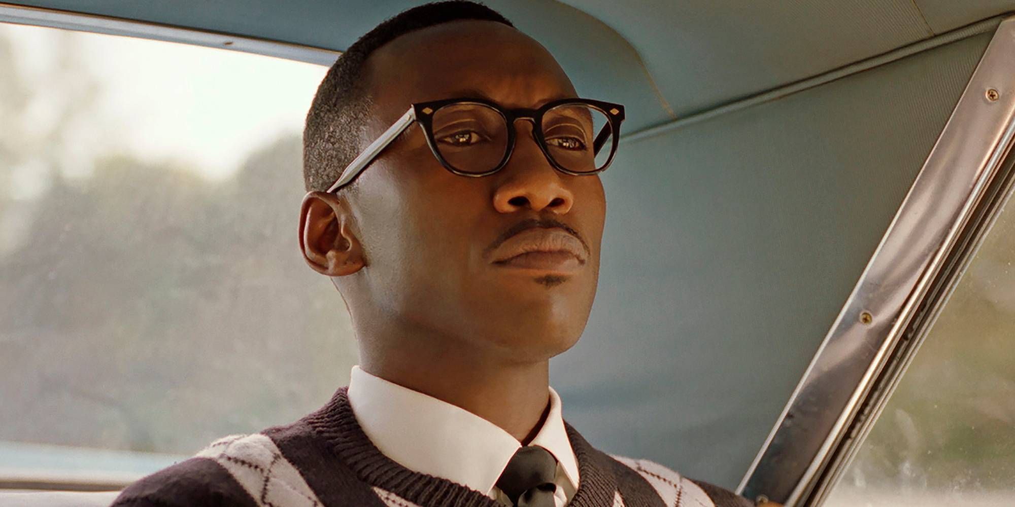 Close-up of Doctor Donaled Shirley, sitting seriously in the back of a car in Green Book