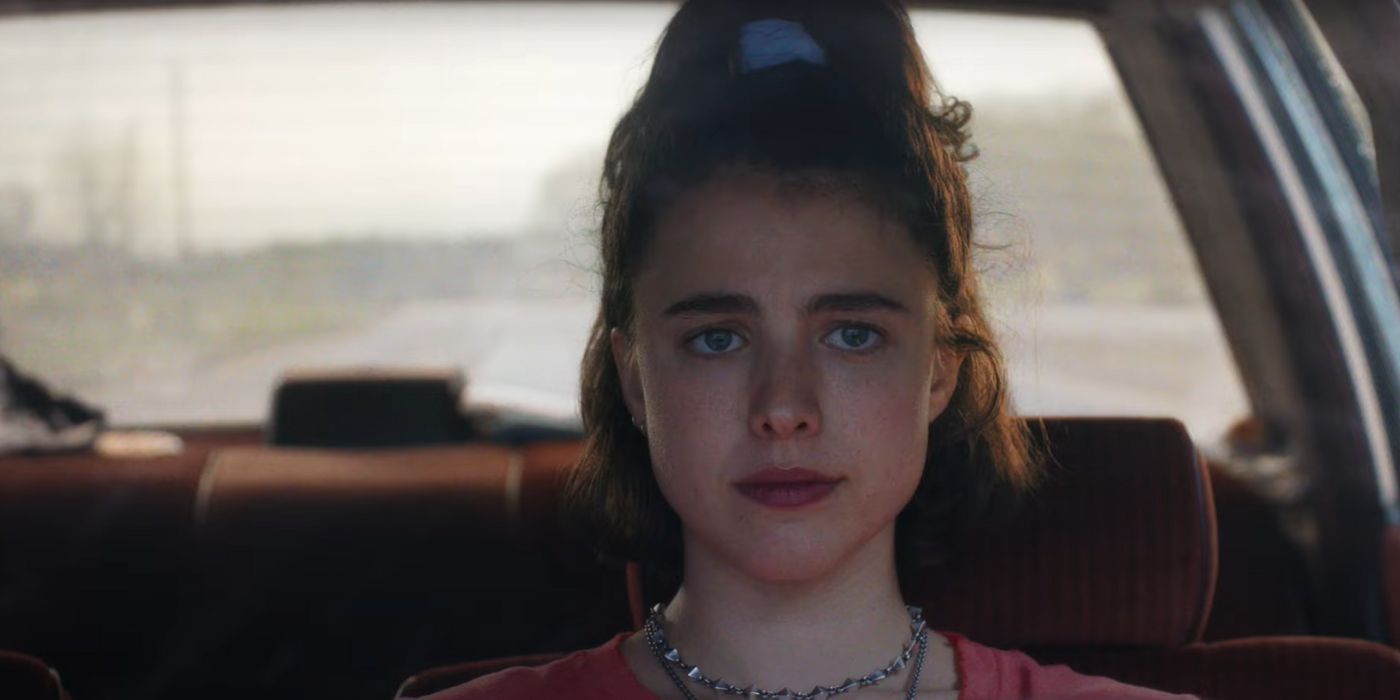 Margaret Qualley as Jamie, sitting in the drivers seat in Drive-Away Dolls