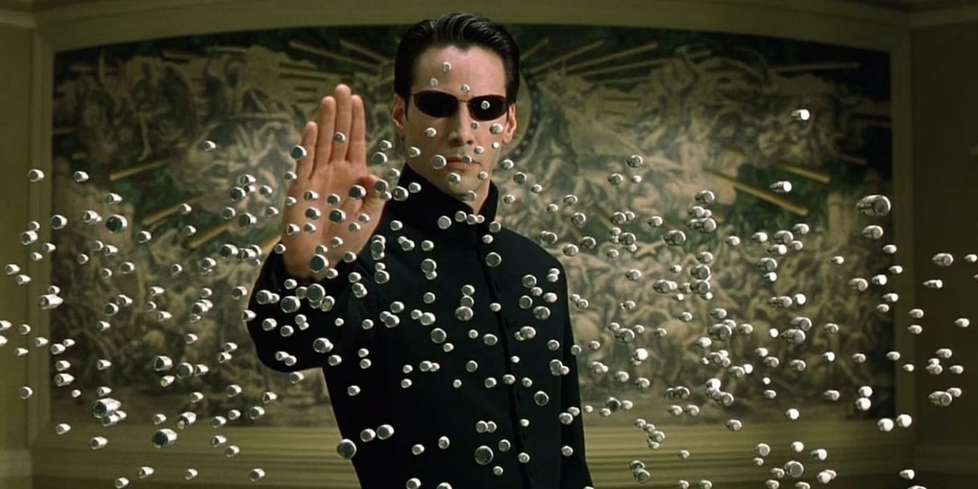 Neo (Keanu Reeves) with a raised hand, stopping bullets with his mind in 'The Matrix Reloaded'.