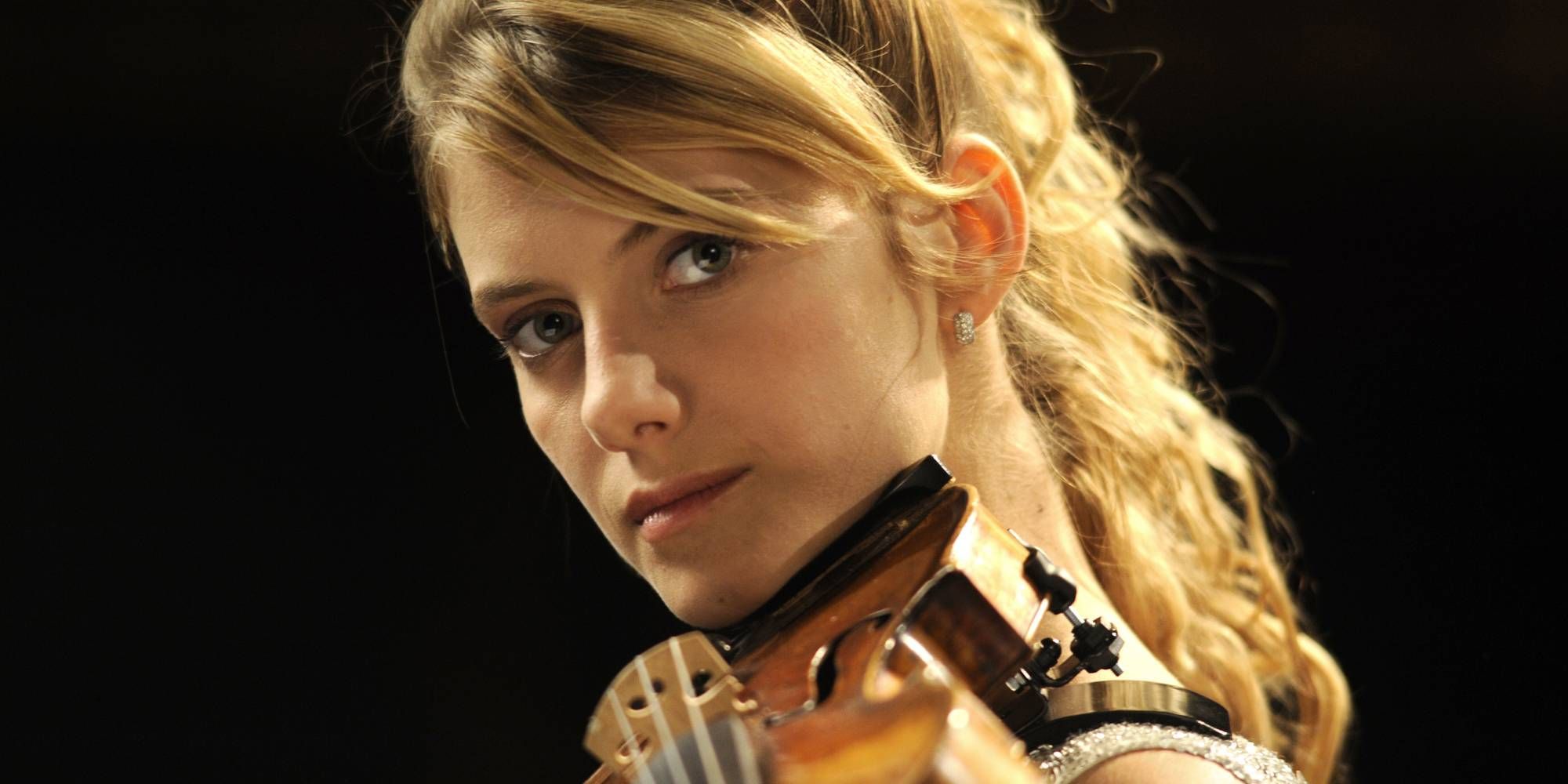 Primer plano de Melanie Laurent tocando el violín en un concierto.