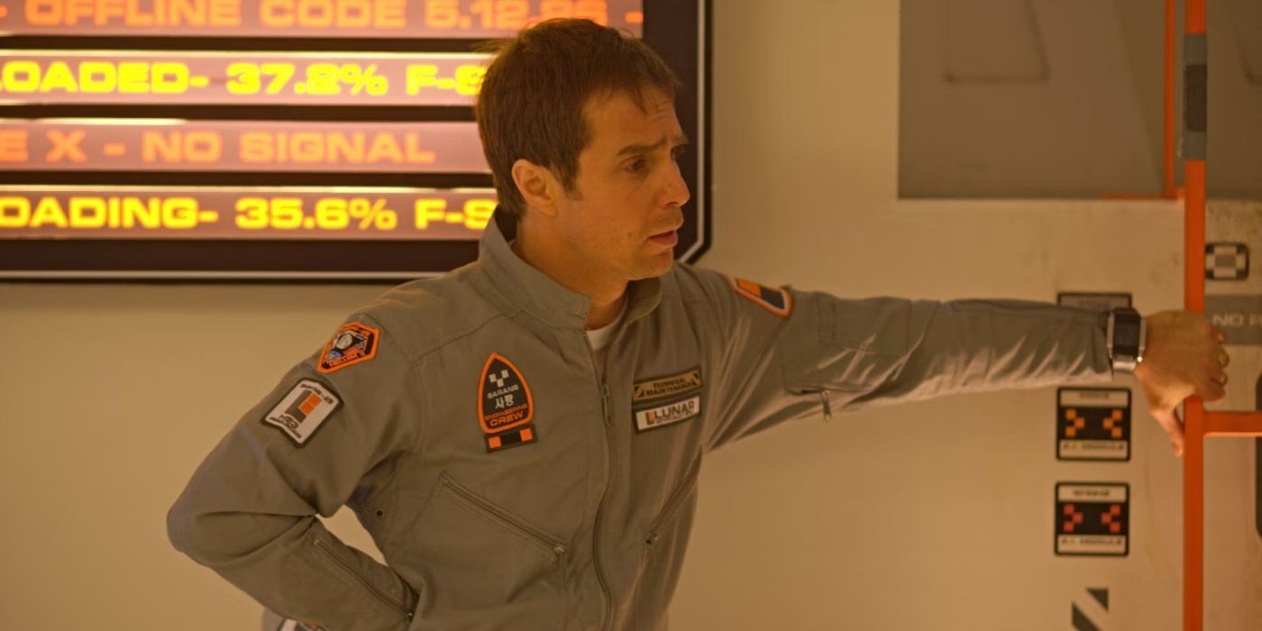 Sam Rockwell as Sam Bell leaning and gripping a small red mini ladder in a white and gray room and looking to the right in Moon