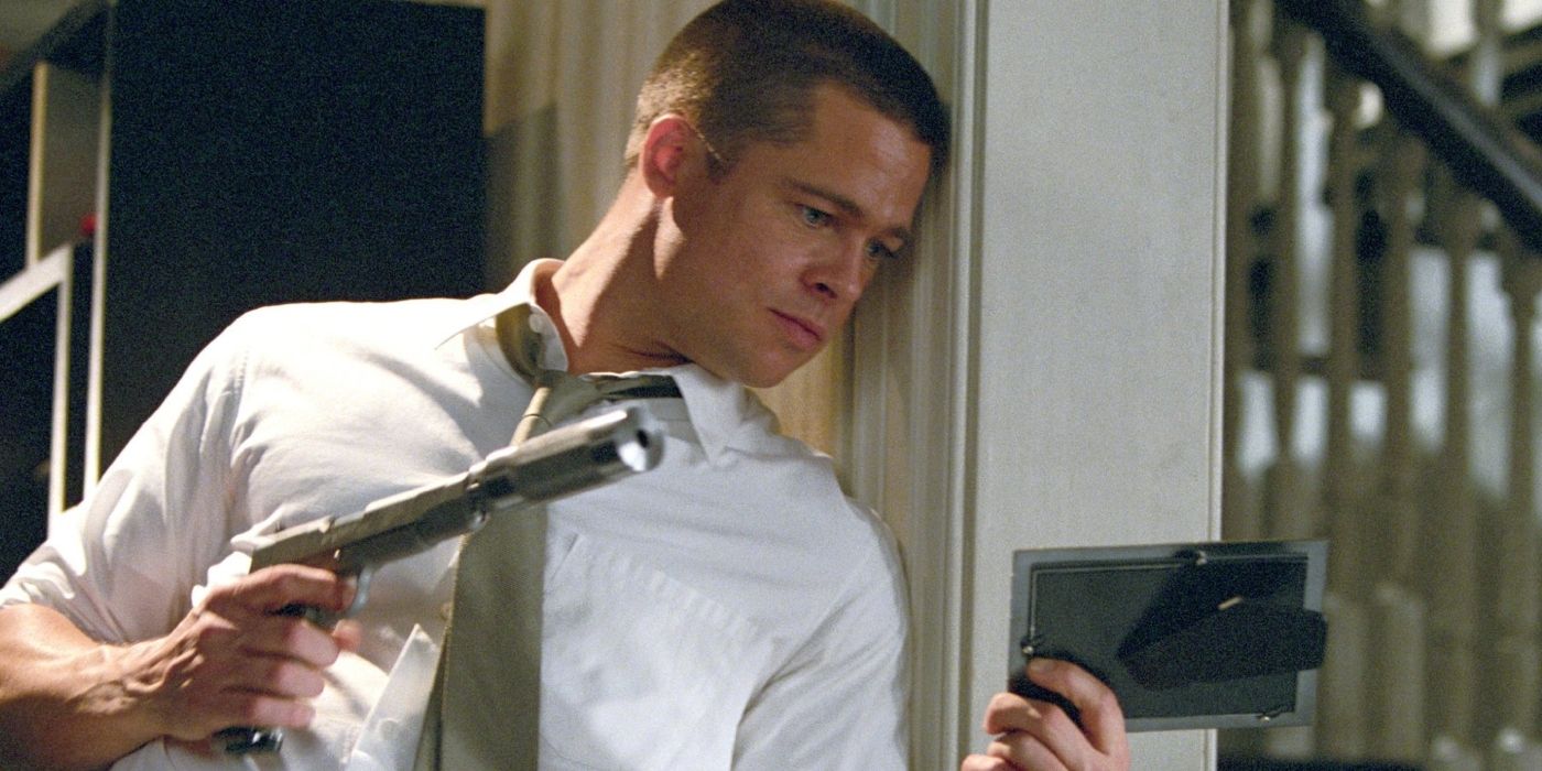 Brad Pitt as John Smith hiding behind a wall as he watches a target through a mirror in Mr. & Mrs. Smith