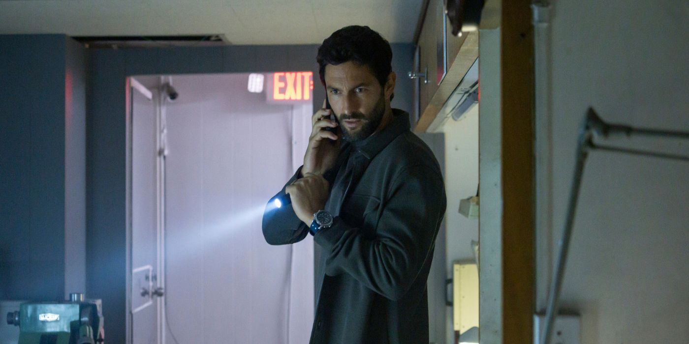 Noah Mills as Jesse Boone, with a phone to his ear and a flashlight in hand, in NCIS: Hawaii.