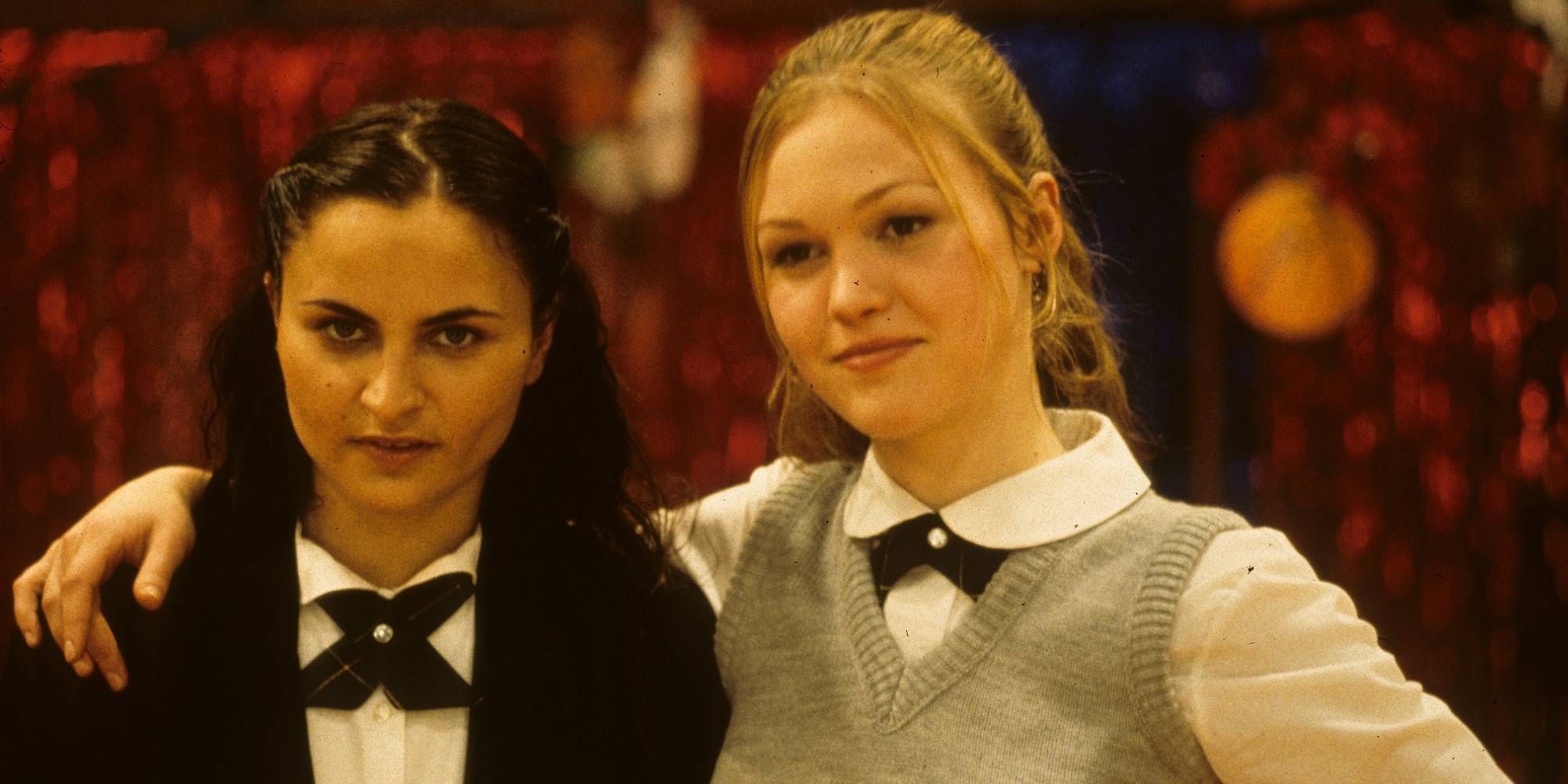 A smiley Julia Stiles with her arm wrapped around Rain Phoenix in O.