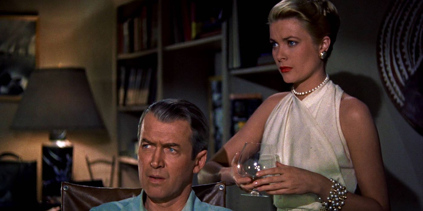 Lisa, played by Grace Kelly, holding a wine glass behind Jeffries, played by Jimmy Stewart, as they both stare to the left in Rear Window
