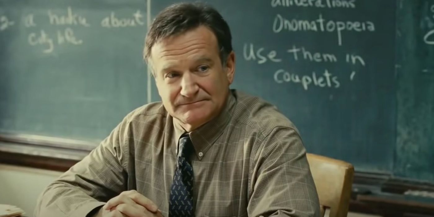 Robin Williams as Lance Clayton, sitting at his desk in front of a blackboard in World's Greatest Dad