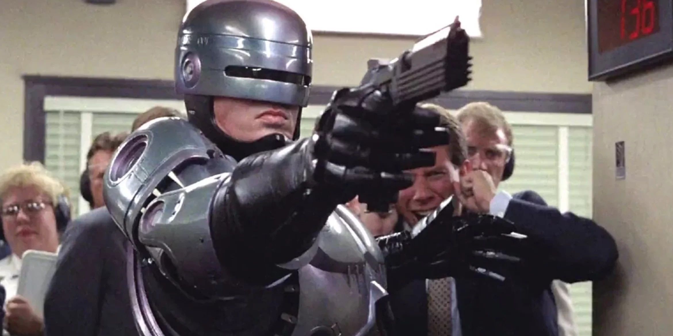 Robocop (Peter Weller) shoots his pistol at the firing range in front of a crowd in 'Robocop'