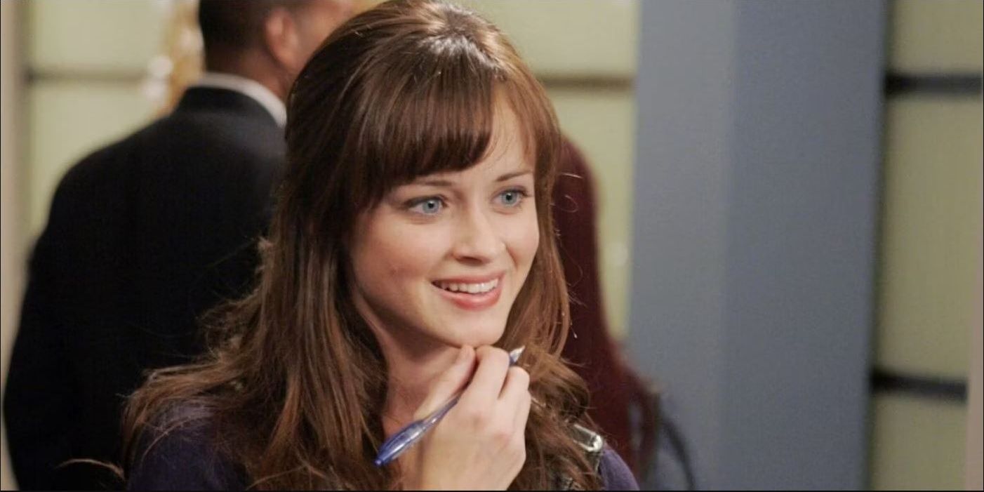 Alexis Bledel as Rory Gilmore smiling while holding a pen in Gilmore Girls.