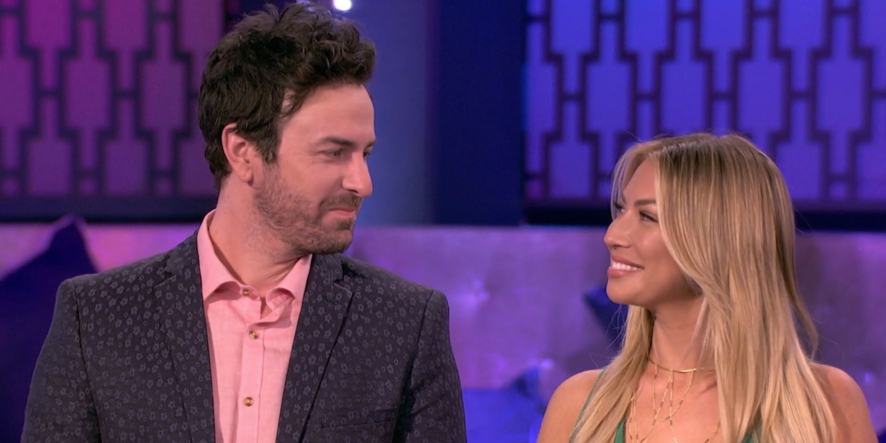 Beau Clark and Stassi Schroeder glance at each other smiling during the season seven reunion of 'Vanderpump Rules'