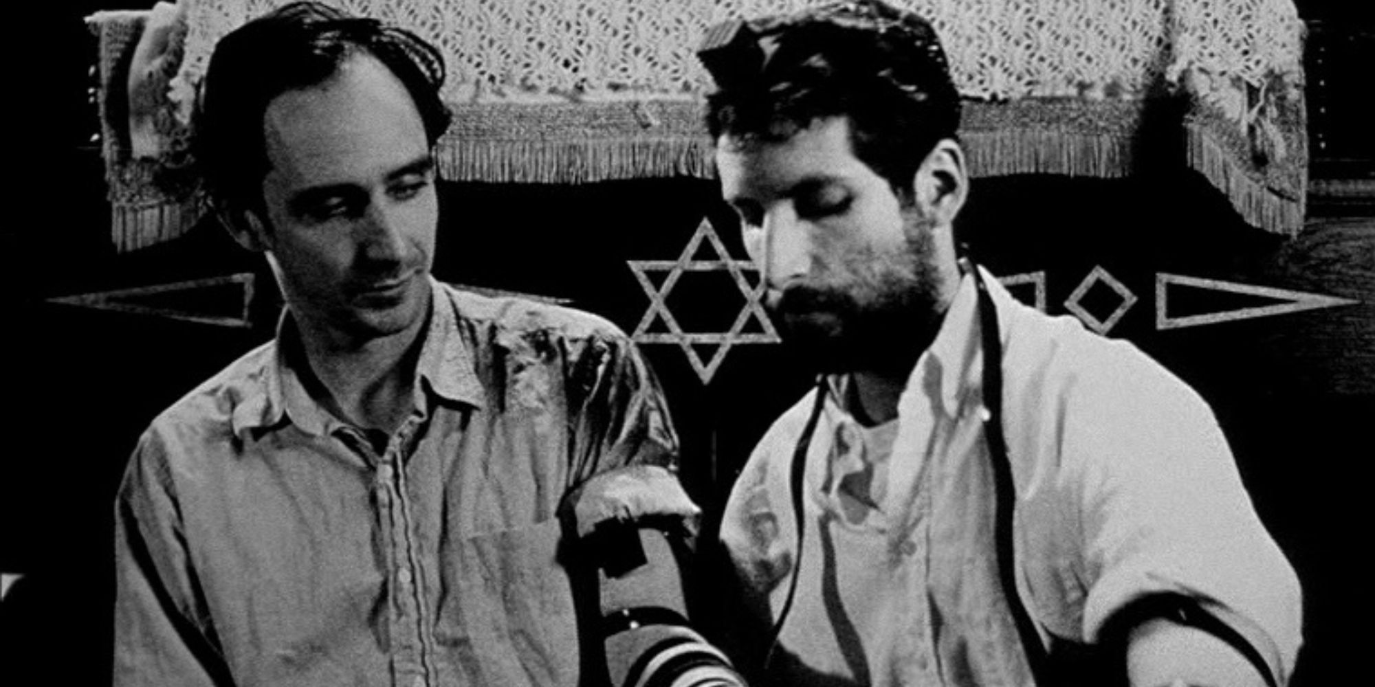 Sean Gullette and Ben Shenkman looking down at something in Pi (1998)