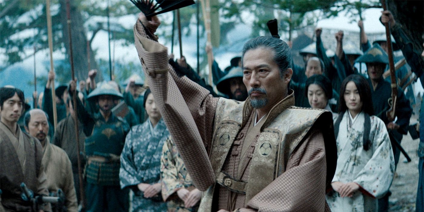 Shogun-Hiroyuki Sanada as Lord Toranaga riasing his right arm with a crowd behind him in FX's Shōgun