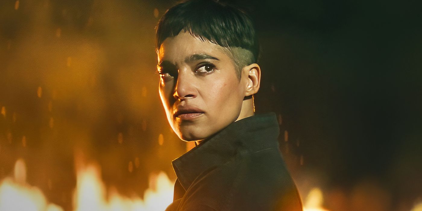 Sofia Boutella as Kora looking back while standing in a burning field in Rebel Moon Part 2