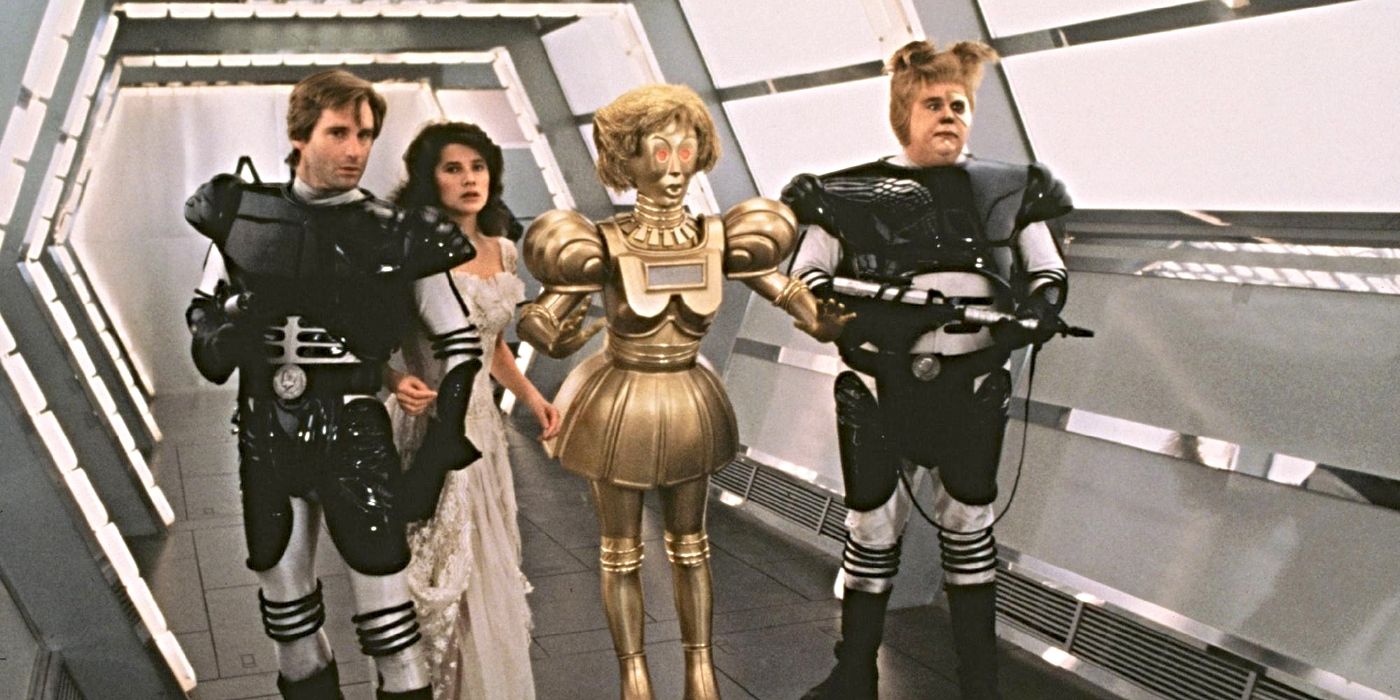 Lone Starr (Bill Pullman), Princess Vespa (Daphne Zuniga), Dot Matrix (Lorene Yarnell Jansson) and Barf (John Dancy) walking down a corridor with weapons in Spaceballs