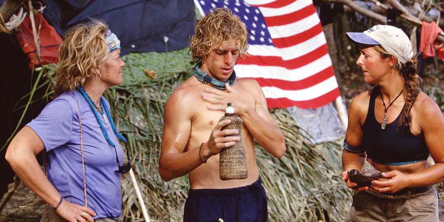 Three contestants at camp with an American flag in the background on Survivor: Marquesas.