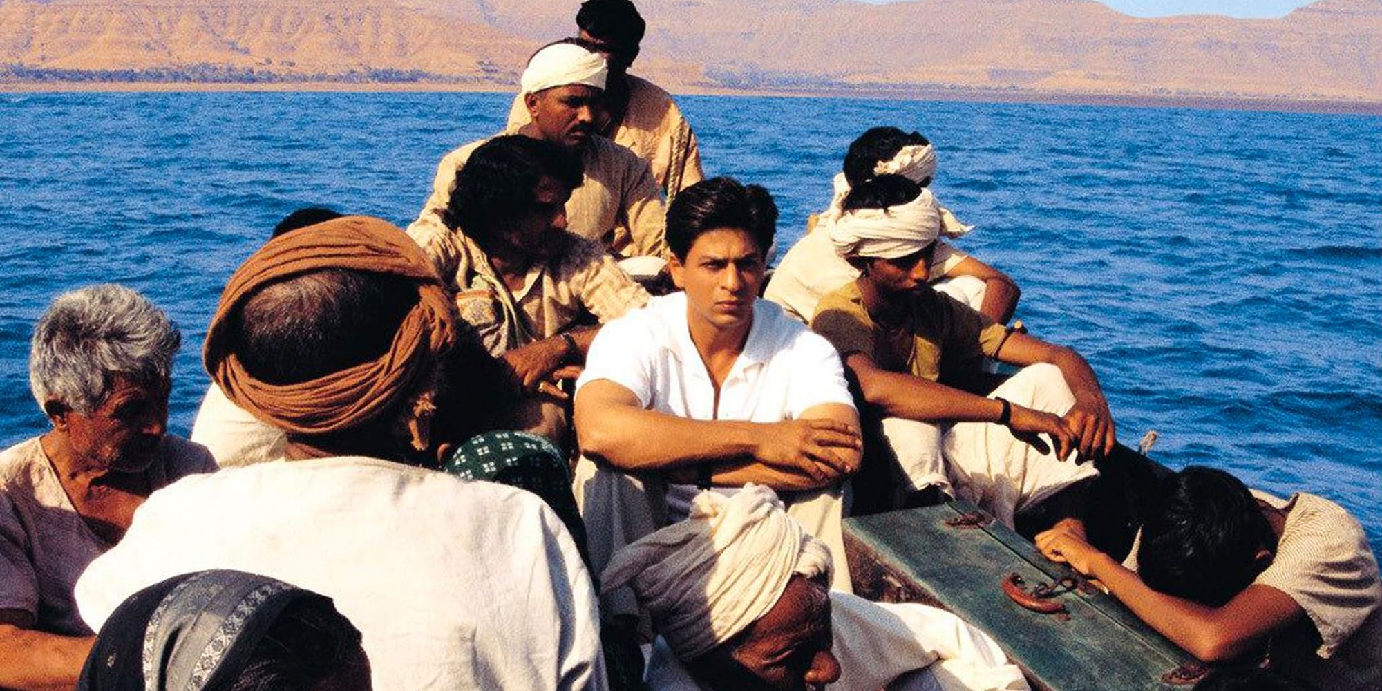 Shah Rukh Khan in a boat with other men in Swades