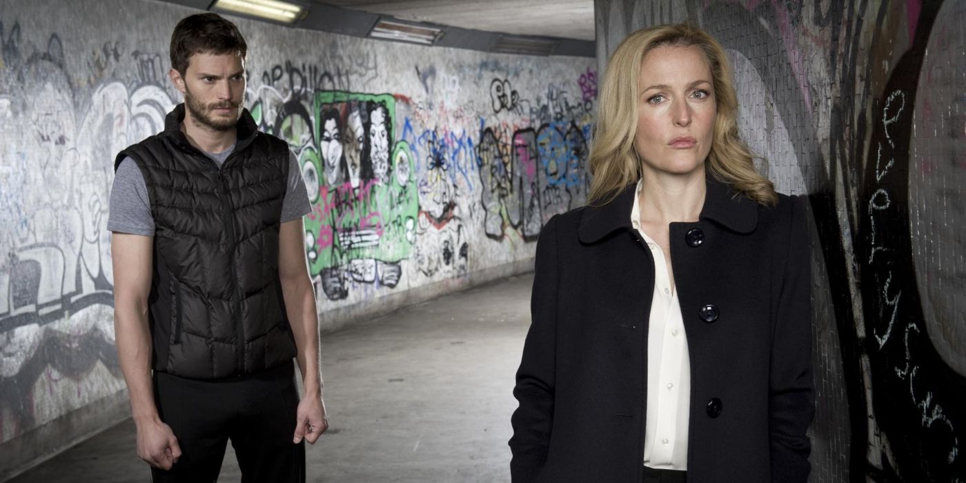 Jamie Dornan as Paul Spector lurking behind Gillian Anderson as Stella Gibson in a long hallway covered in graffiti, in The Fall