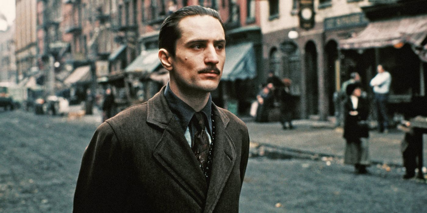 A young Robert De Niro standing in the street in a scene from The Godfather Part II.