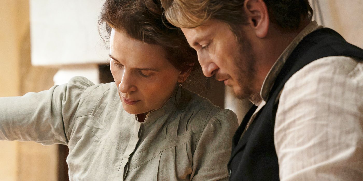 Benoît Magimel as Dodin and Juliette Binoche as Eugénie intensely looking over the culinary art they're making together in their kitchen in The Taste of Things. 