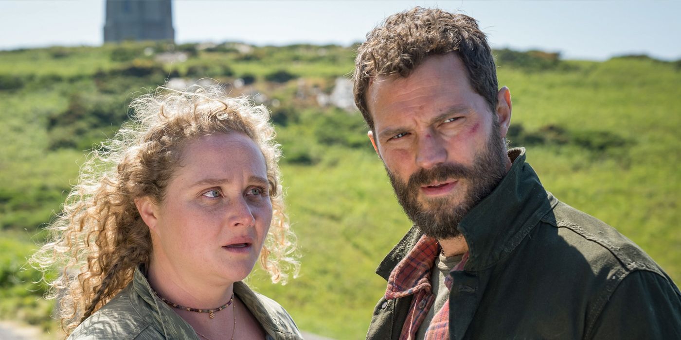 A curly, blonde-haired woman (Danielle Macdonald) and dark-haired man (Jamie Dornan) stand in a field while in Ireland in a scene from The Tourist Season 2.