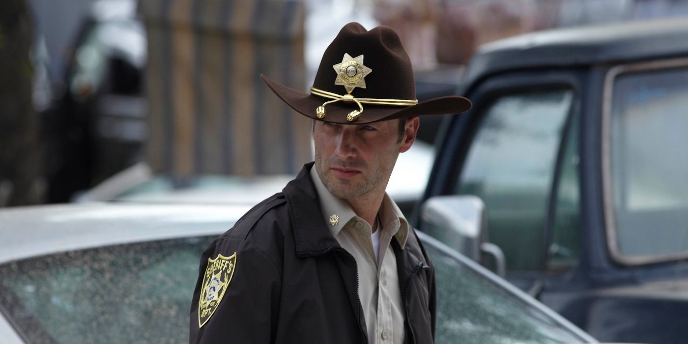 Andrew Lincoln as Rick Grimes in The Walking Dead wearing his sheriff hat and jacket, looking back.