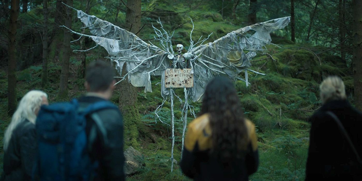 A group of four people staring at a winged skeleton in The Watchers.