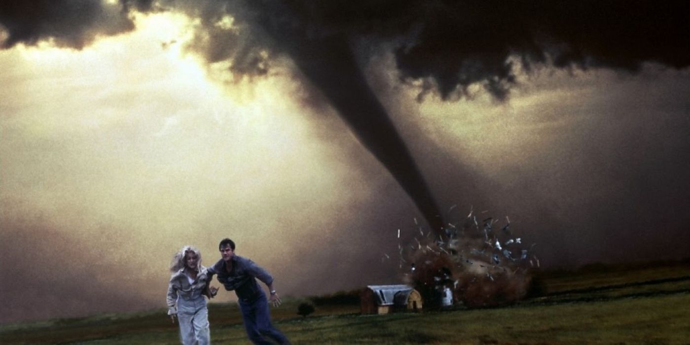 A man and a woman run from a tornado