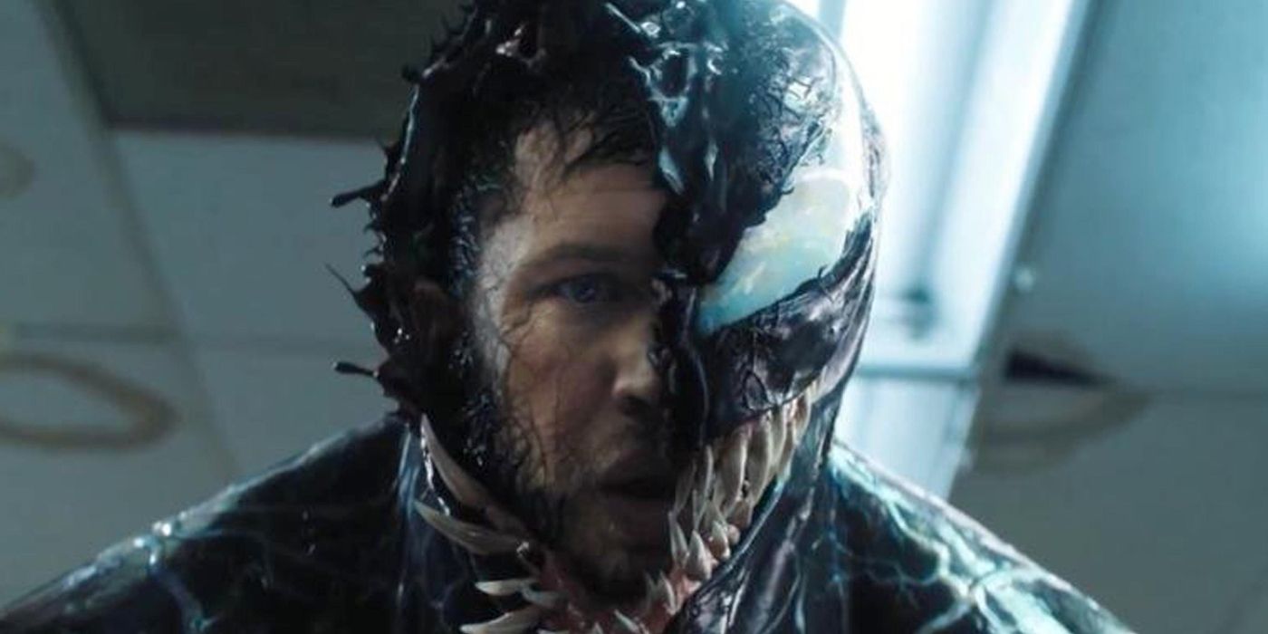 Tom Hardy as Eddie Brock, looking stressed as Venom covers his face in Venom