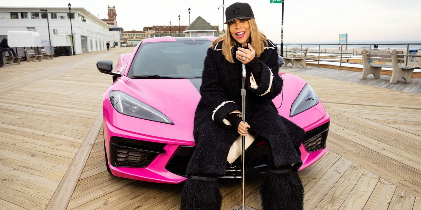 Wendy Williams poses in front of a pink car on 'Where Is Wendy Williams